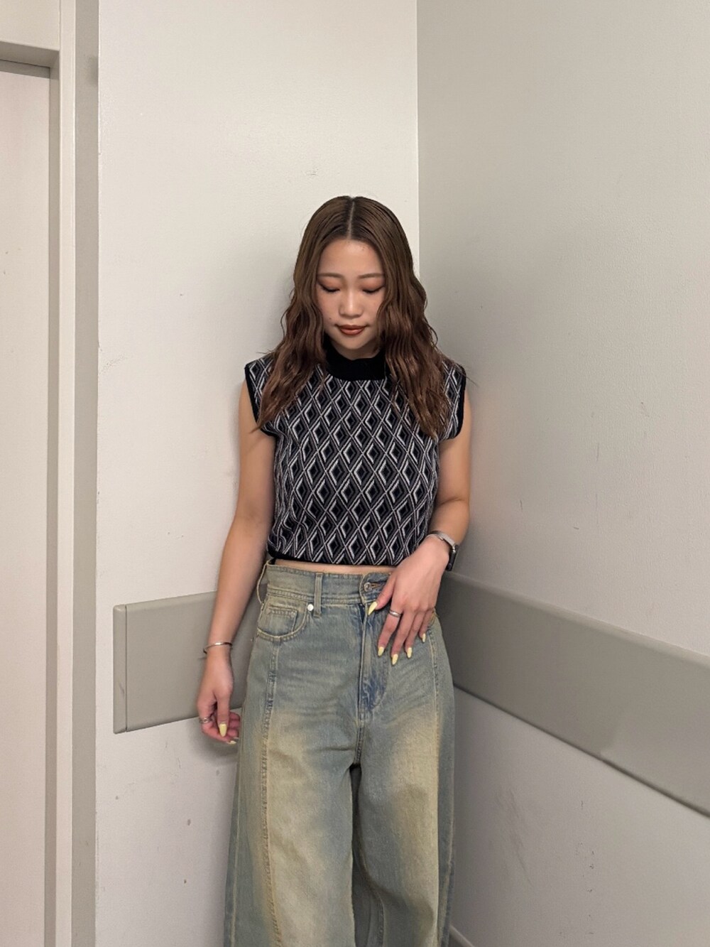 ブルー系のデニムパンツ、ブラック系のタンクトップ、ブラック系のサンダルを着用したレディースの夏コーディネートの4枚目の写真