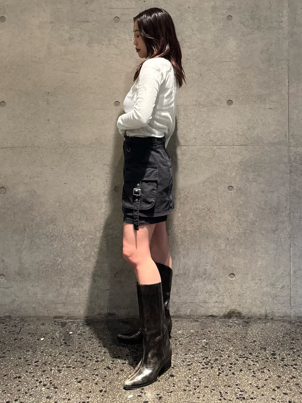 ホワイト系のTシャツ/カットソー、ブラック系のスカート、ブラウン系のブーツを着用したレディースの春コーディネートの2枚目の写真