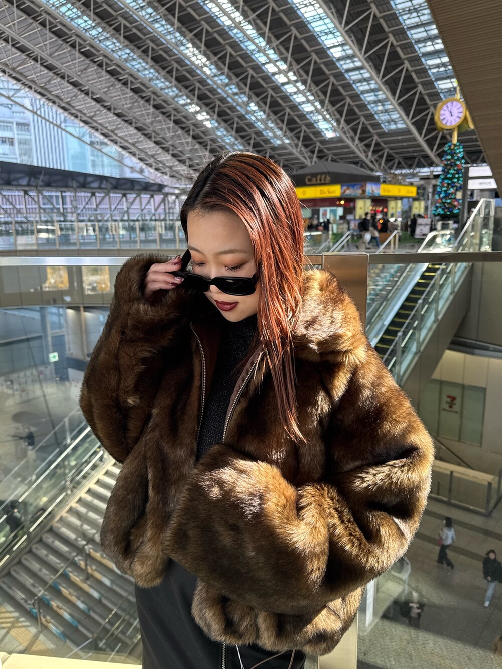 ブラウン系のブルゾン、ブラック系のスカート、ブラック系のブーツを着用したレディースの冬コーディネートの4枚目の写真