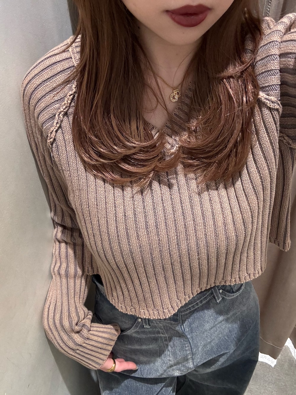 グレー系のデニムパンツ、ベージュ系のニット/セーター、ブラック系のブーツを着用したレディースの冬コーディネートの5枚目の写真