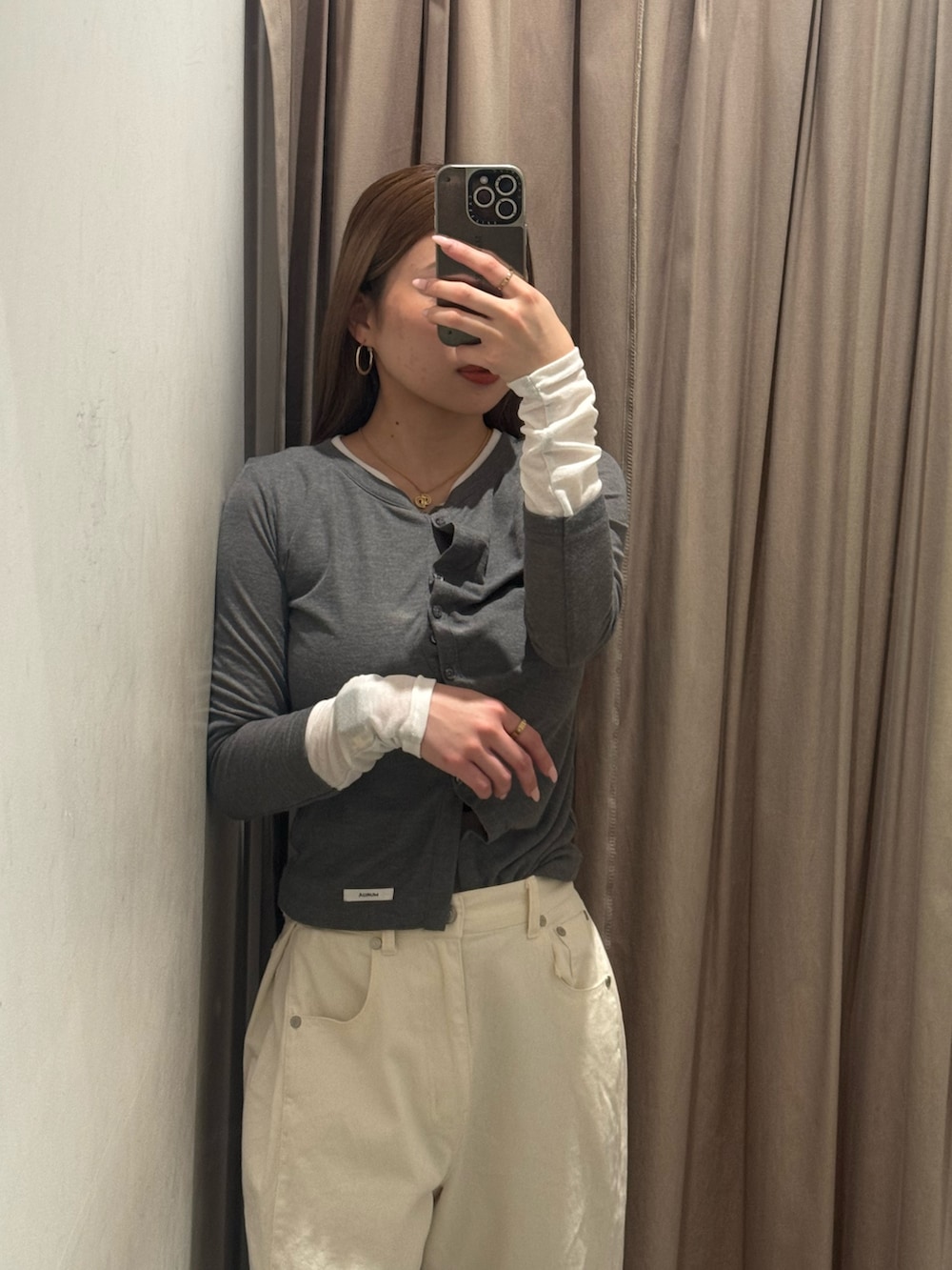 ホワイト系のデニムパンツ、グレー系のカーディガン/ボレロ、ブラック系のブーツを着用したレディースの春コーディネートの4枚目の写真