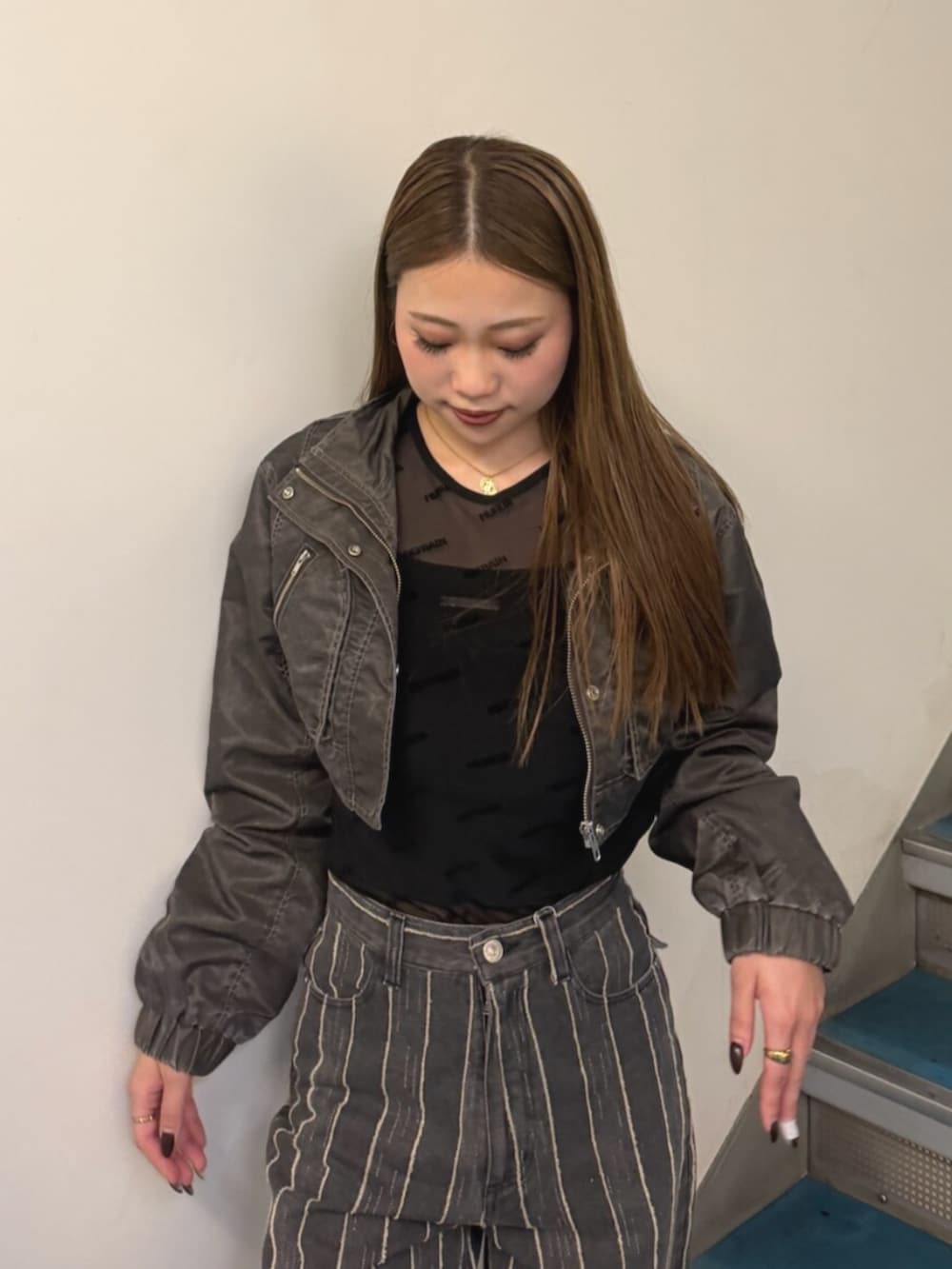 ブラック系のTシャツ/カットソー、ブラック系のデニムパンツ、ブラック系のブーツを着用したレディースの秋コーディネートの4枚目の写真