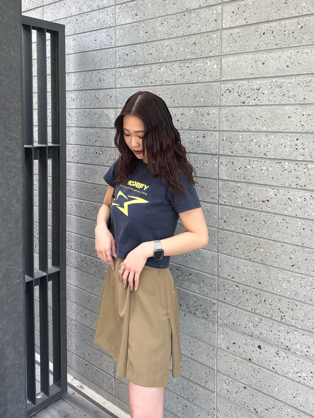 ブルー系のTシャツ/カットソー、ベージュ系のスカート、ブラック系のブーツを着用したレディースの春コーディネートの4枚目の写真