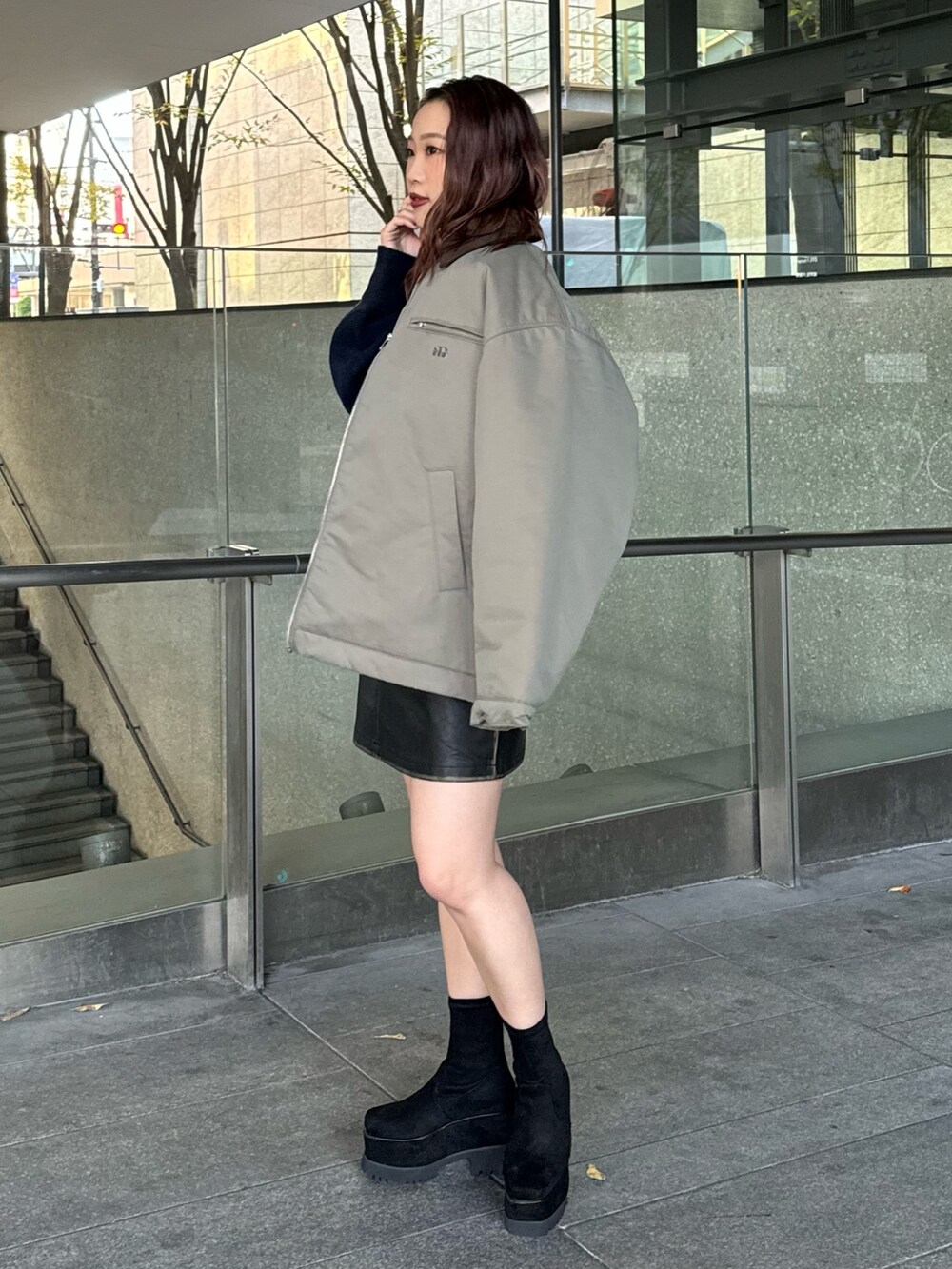 ブルー系のニット/セーター、ブラック系のスカート、ブラック系のブーツを着用したレディースの秋コーディネートの2枚目の写真