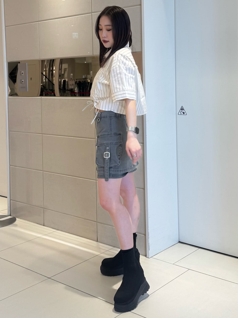 ホワイト系のシャツ/ブラウス、グレー系のスカート、ブラック系のブーツを着用したレディースの春コーディネートの2枚目の写真