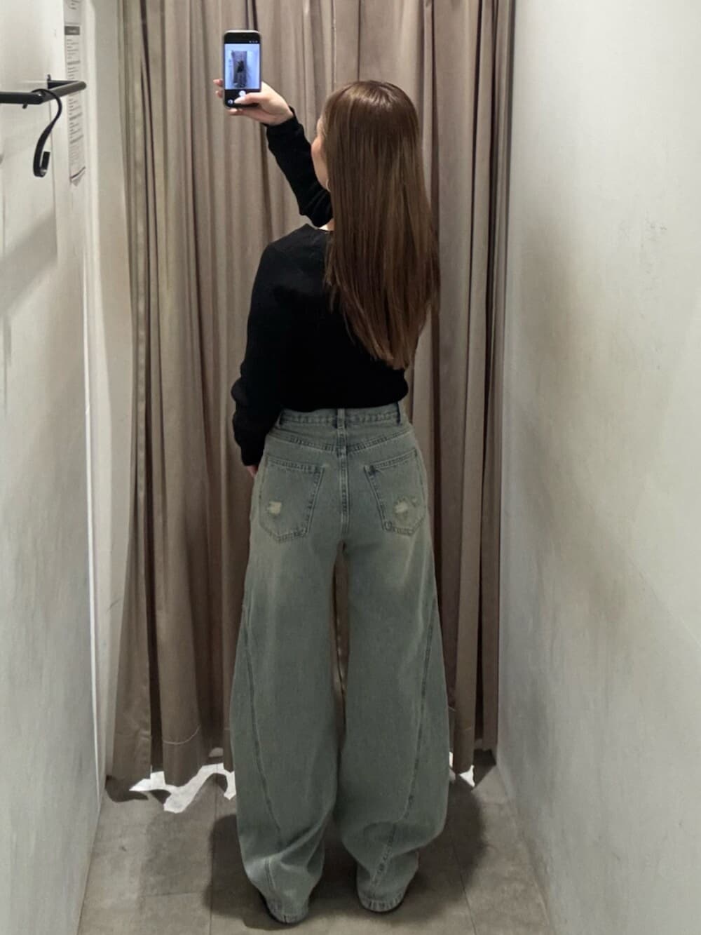 ブラック系のブーツ、ブルー系のデニムパンツ、ブラック系のニット/セーターを着用したレディースの春コーディネートの3枚目の写真