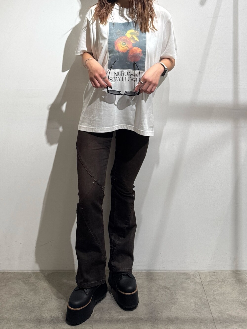 ホワイト系のTシャツ/カットソー、ブラウン系のデニムパンツ、ブラック系のブーツを着用したレディースの夏コーディネートの5枚目の写真