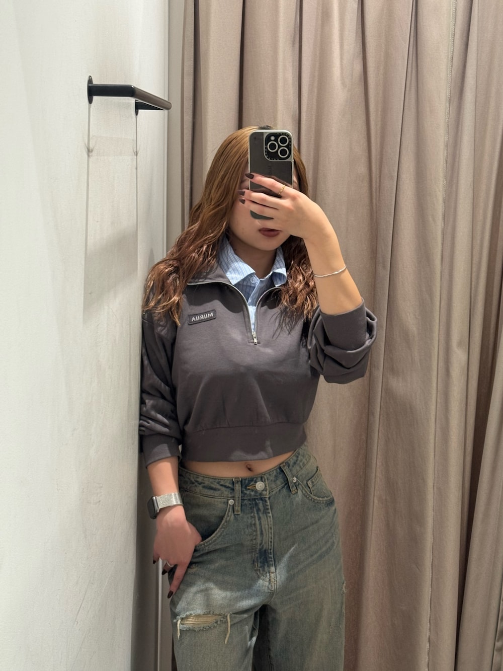 グレー系のスウェット、ブルー系のデニムパンツ、ブラック系のブーツを着用したレディースの秋コーディネートの4枚目の写真