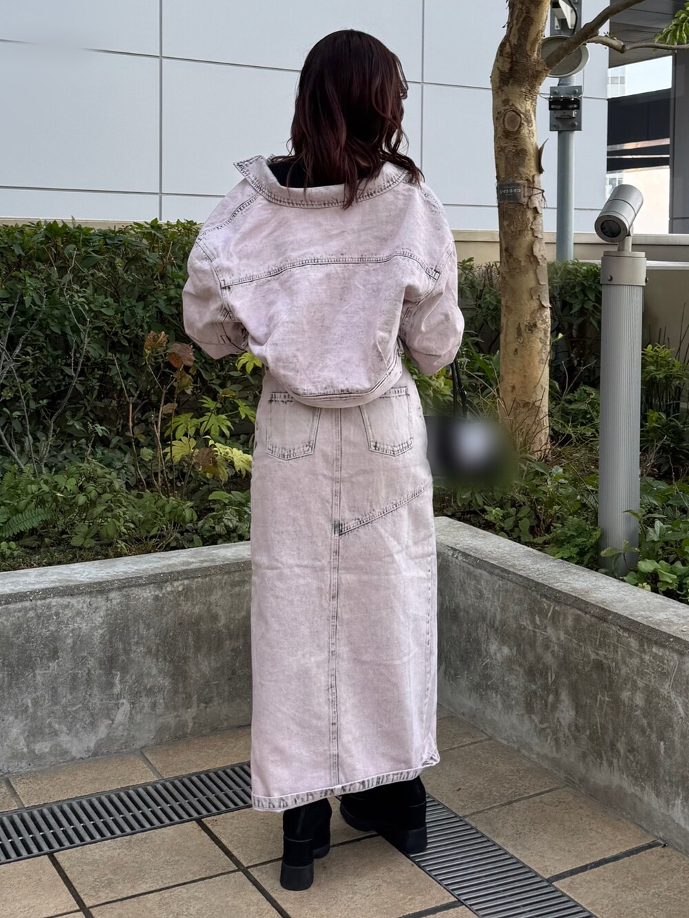 ピンク系のセットアップ、ブラック系のニット/セーター、ブラック系のブーツを着用したレディースの冬コーディネートの3枚目の写真
