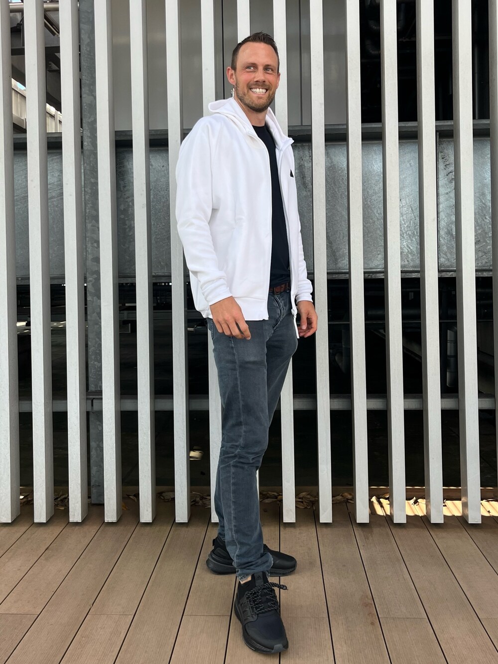 ホワイト系のトップス、ブラック系のスニーカーを着用したメンズの秋コーディネートの5枚目の写真