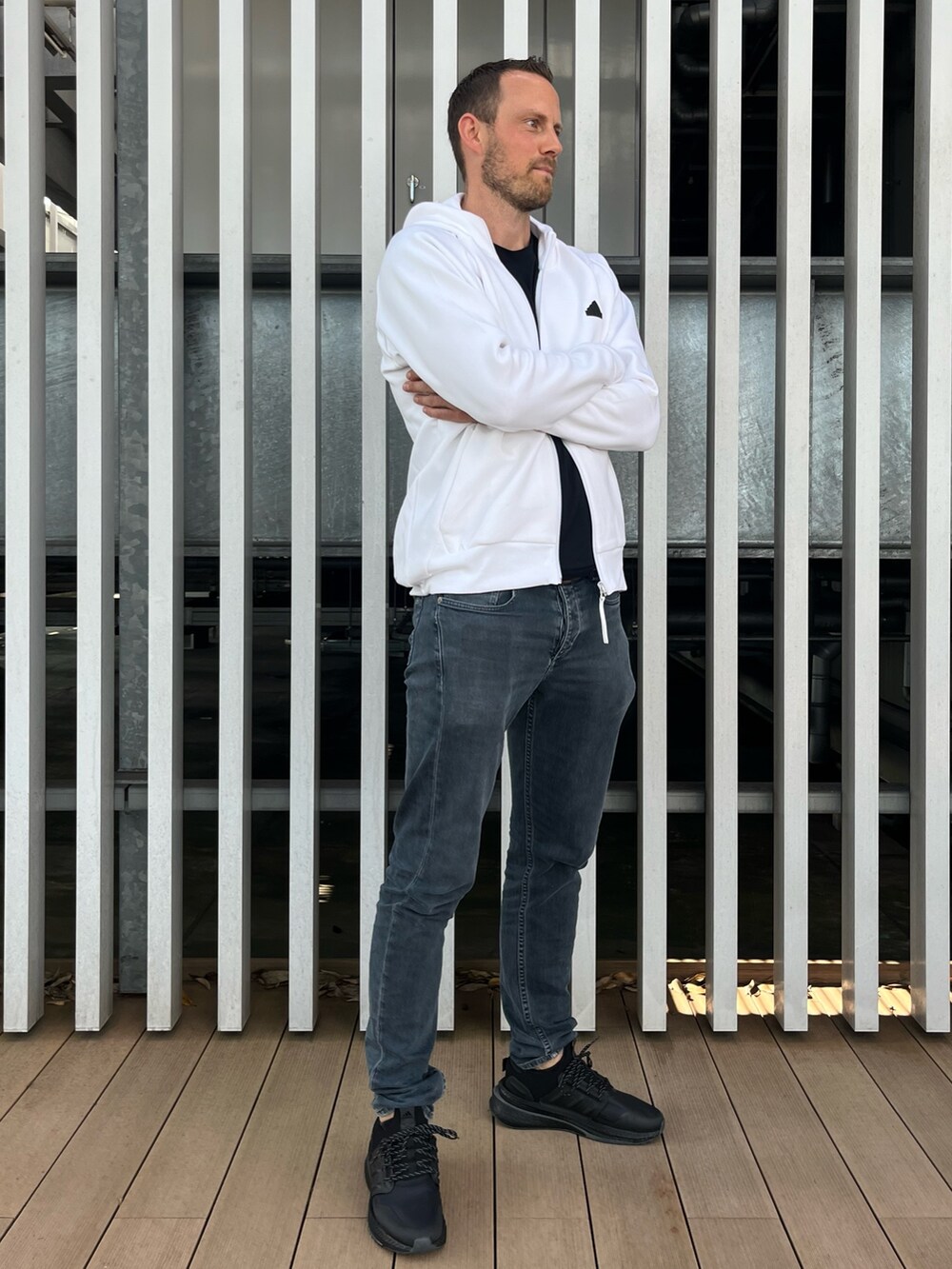 ホワイト系のトップス、ブラック系のスニーカーを着用したメンズの秋コーディネートの3枚目の写真