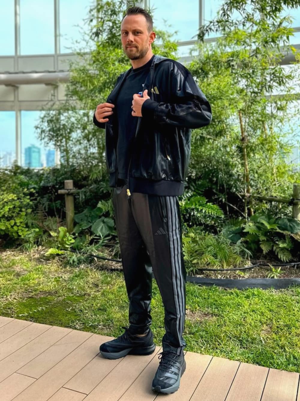 ブラック系のパーカー、ブラック系のスウェットパンツ、ブラック系のシューズを着用したメンズの秋コーディネートの2枚目の写真