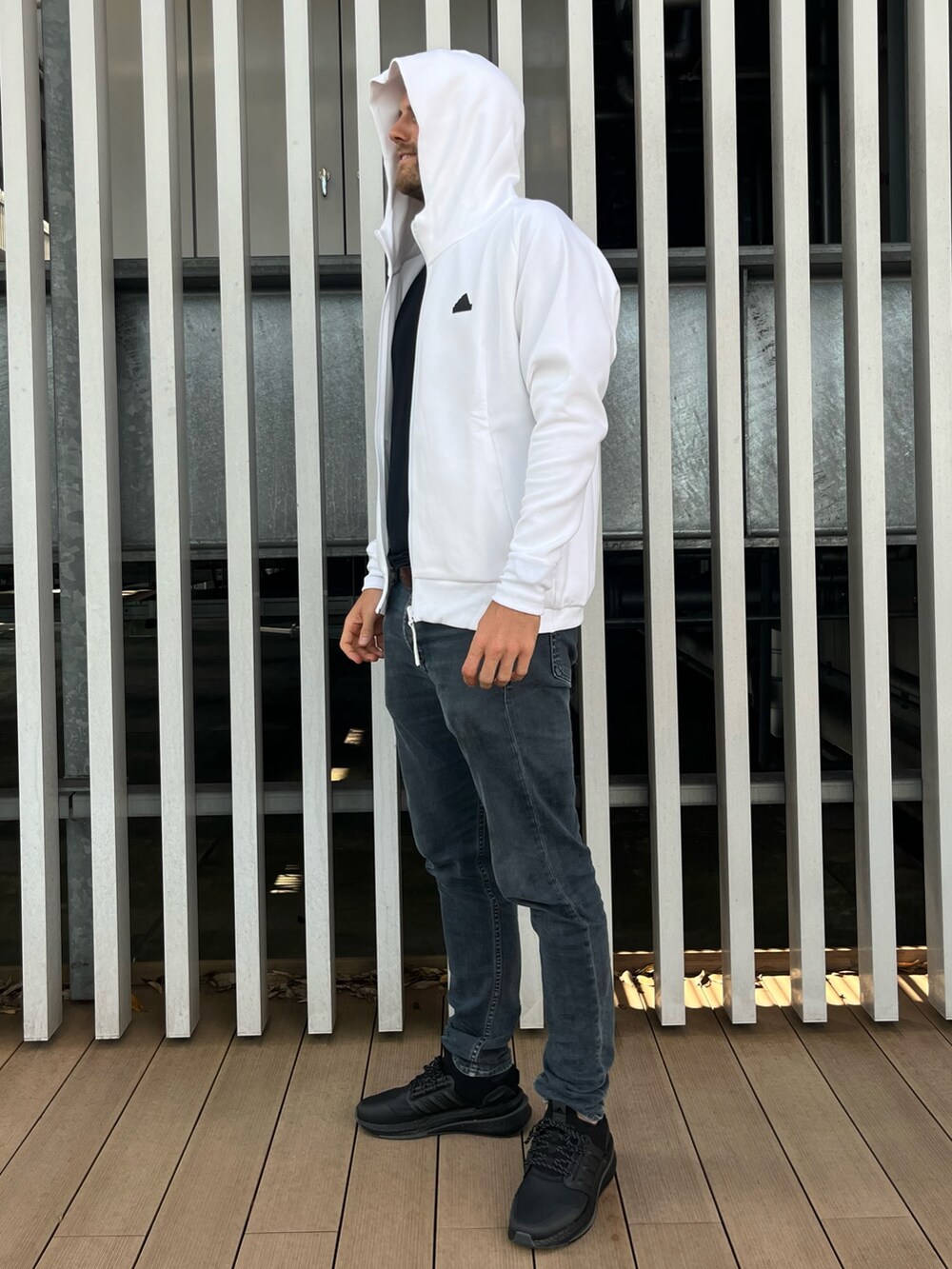 ホワイト系のトップス、ブラック系のスニーカーを着用したメンズの秋コーディネートの4枚目の写真