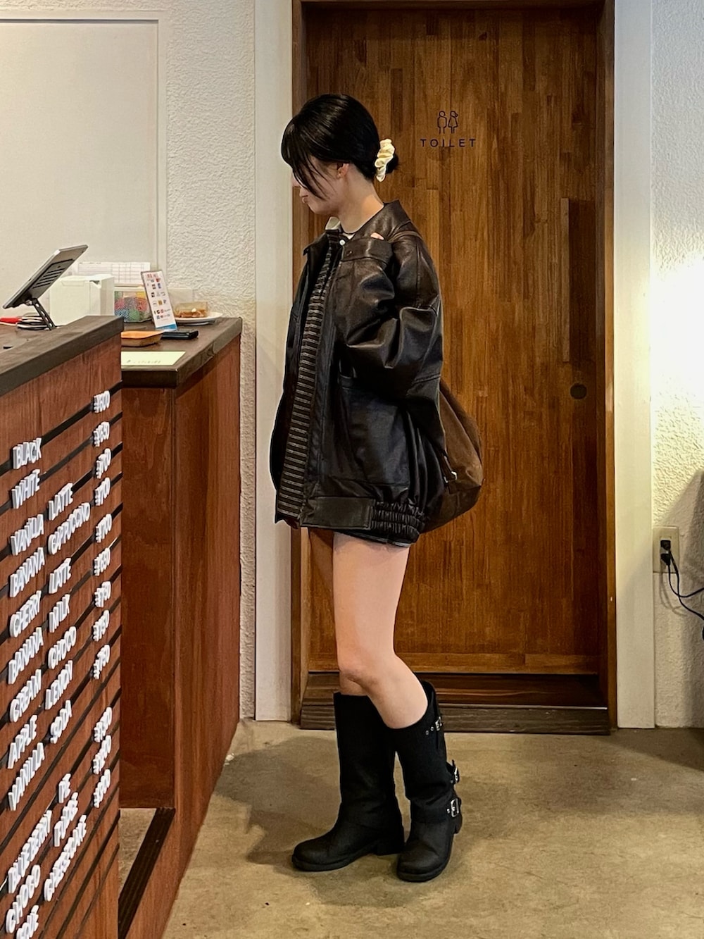 ブラウン系のブルゾン、ブラウン系のTシャツ/カットソー、ブラウン系のショルダーバッグを着用したレディースの冬コーディネートの3枚目の写真