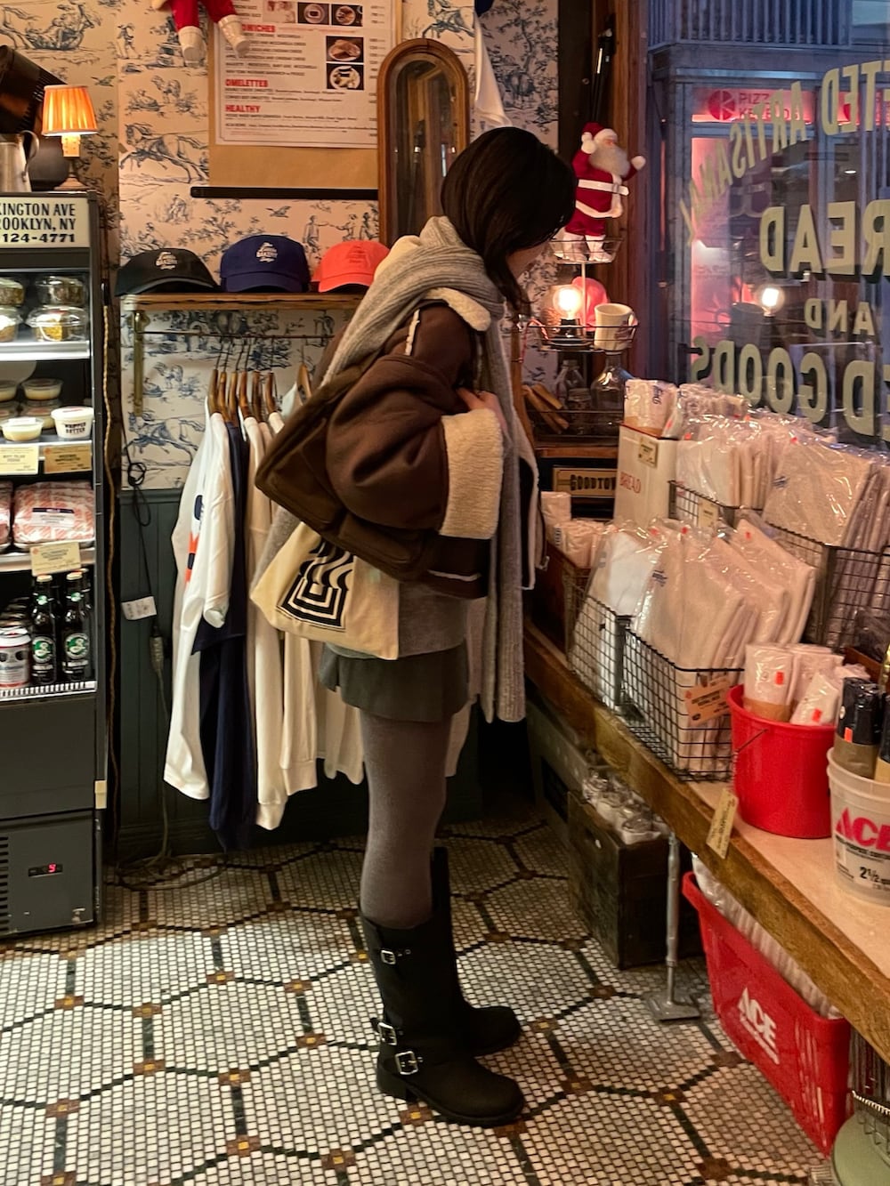 ブラウン系のムートンコート、グレー系のニット/セーター、ブラウン系のショルダーバッグを着用したレディースの冬コーディネートの3枚目の写真