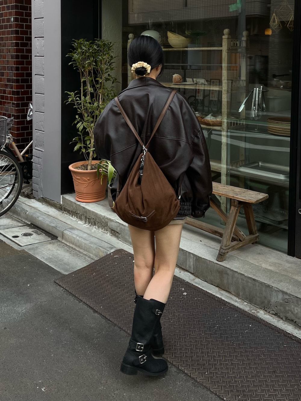 ブラウン系のブルゾン、ブラウン系のTシャツ/カットソー、ブラウン系のショルダーバッグを着用したレディースの冬コーディネートの4枚目の写真