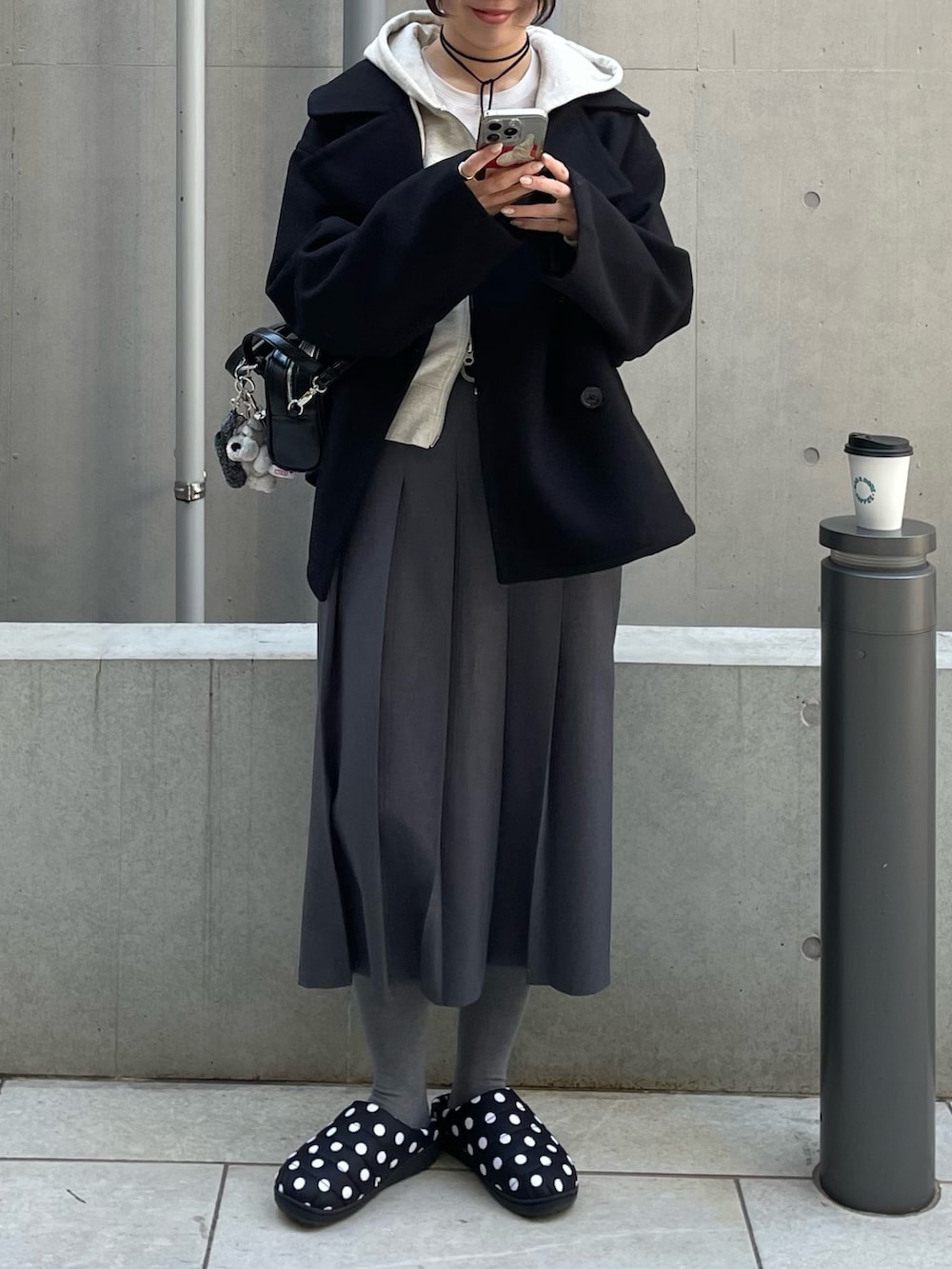 ブラック系のピーコート、ホワイト系のパーカー、ブラック系のボストンバッグを着用したレディースの冬コーディネートの3枚目の写真