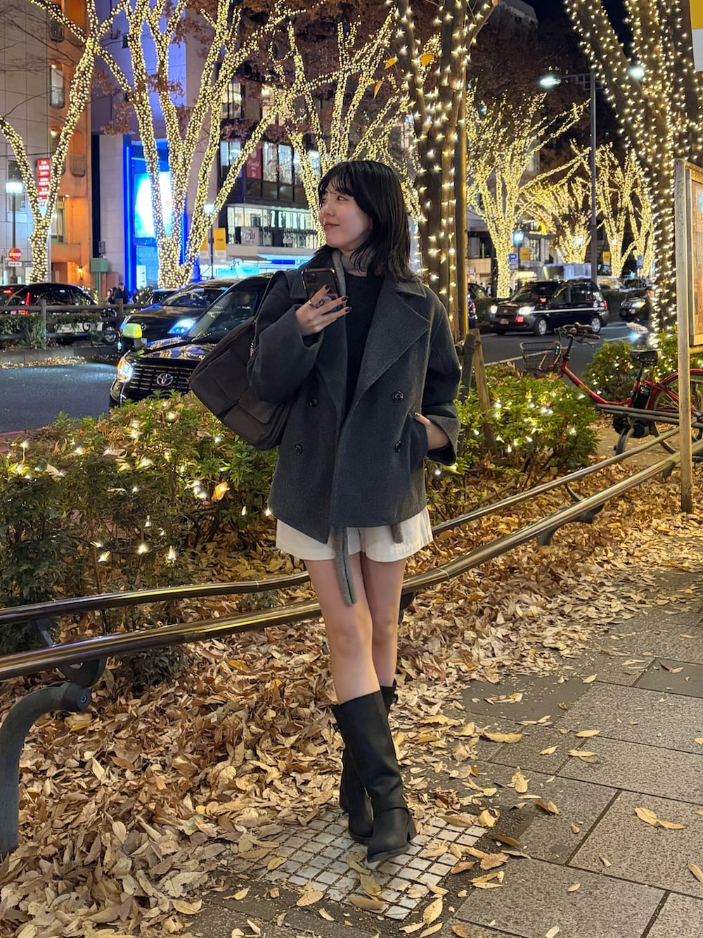 グレー系のピーコート、ブラウン系のショルダーバッグ、グレー系のニット/セーターを着用したレディースの冬コーディネートの4枚目の写真