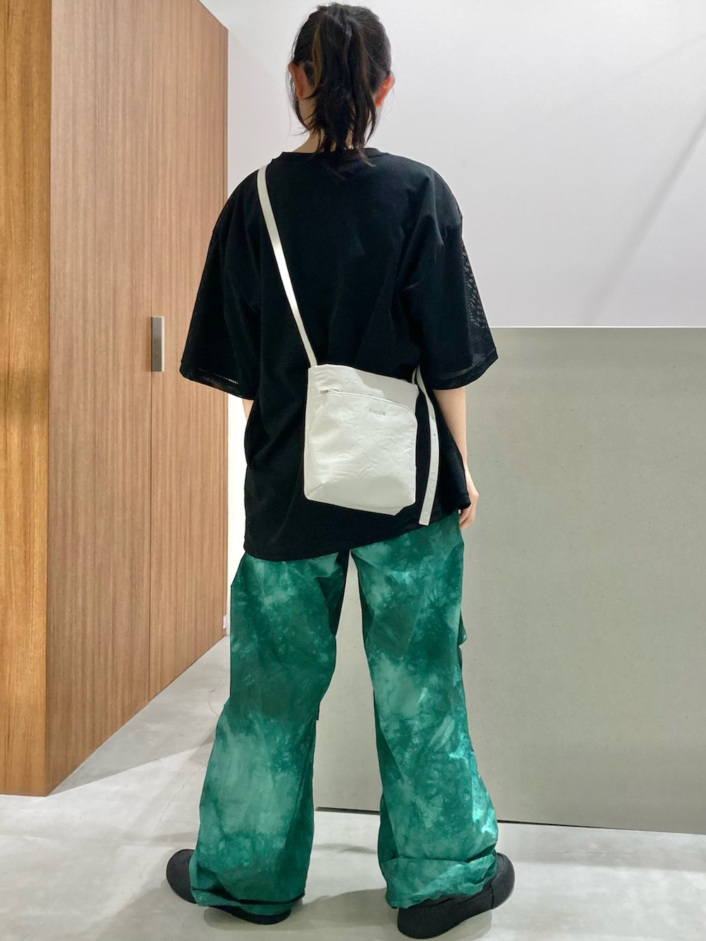 ブラック系のTシャツ/カットソー、ホワイト系のショルダーバッグ、グリーン系のその他パンツを着用したレディースの春コーディネートの3枚目の写真