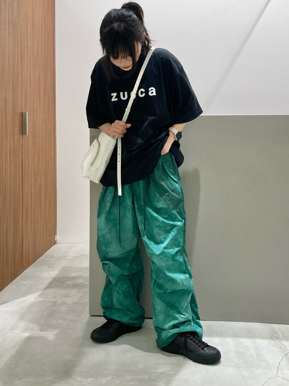 ブラック系のTシャツ/カットソー、ホワイト系のショルダーバッグ、グリーン系のその他パンツを着用したレディースの春コーディネートの2枚目の写真