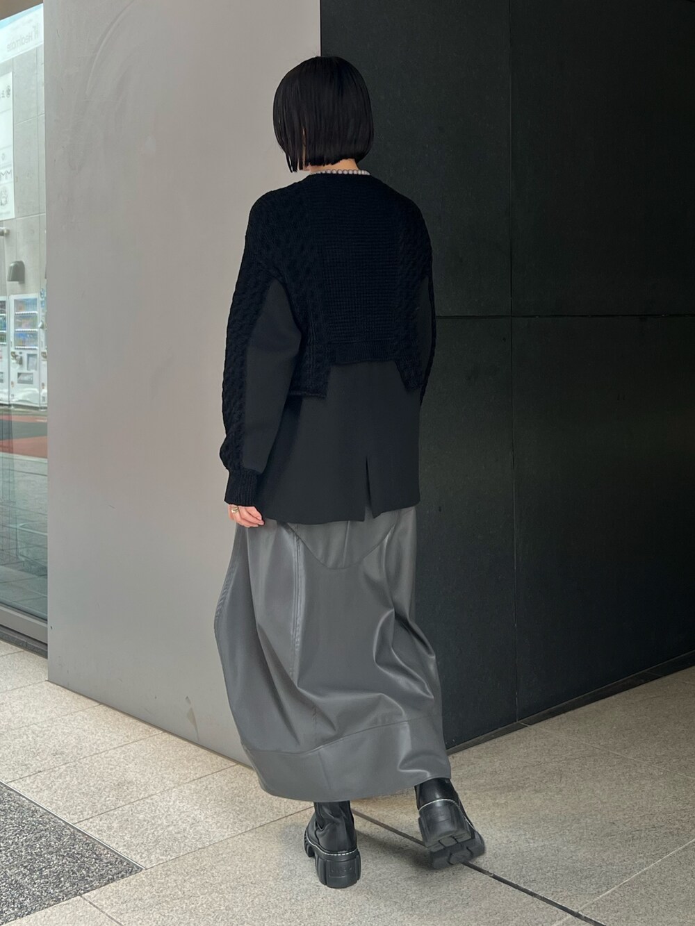 ブラック系のニット/セーター、グレー系のスカート、ブラック系のブーツを着用したレディースの秋コーディネートの3枚目の写真