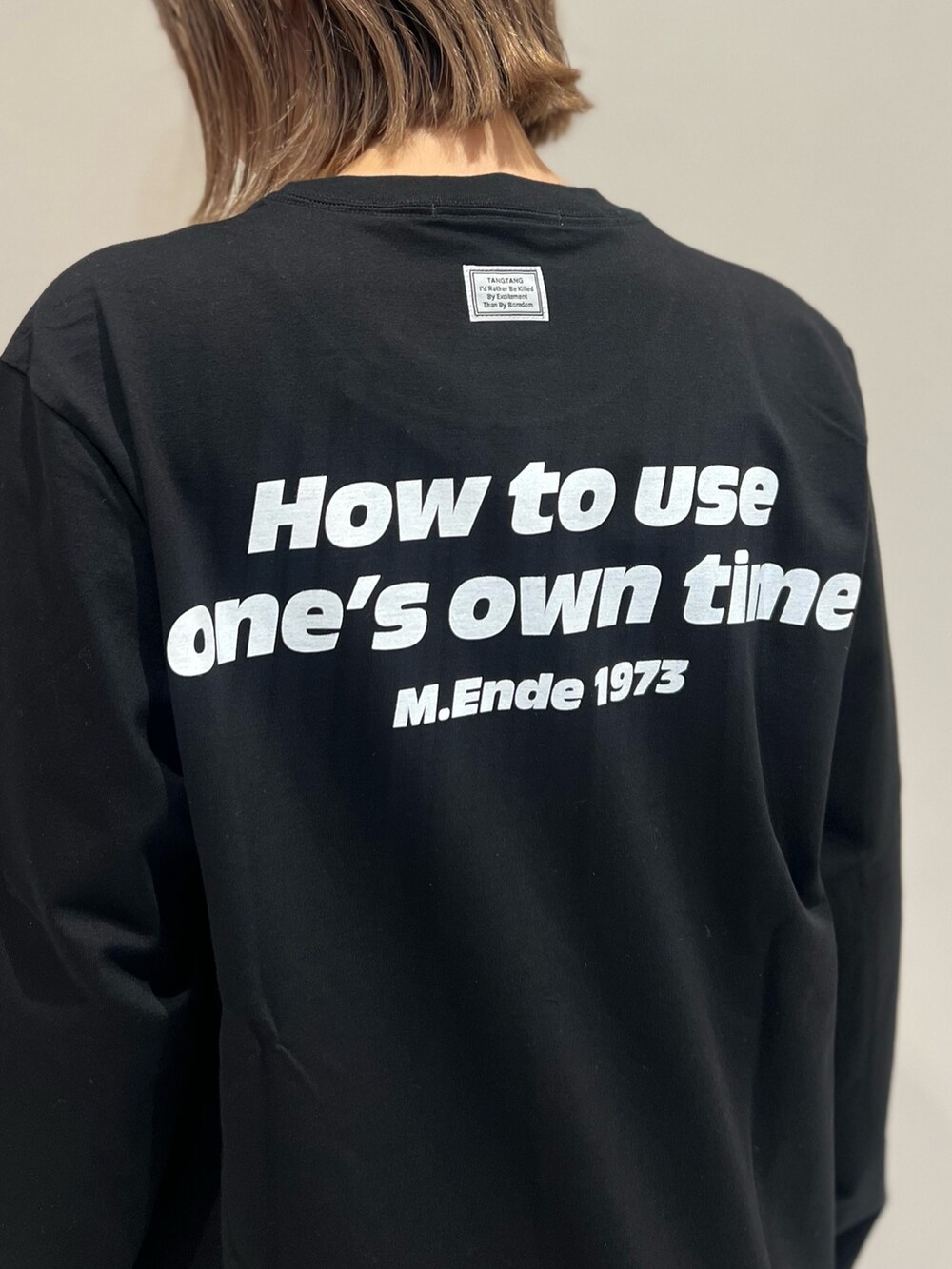 ブラック系のTシャツ/カットソー、ブラック系のショルダーバッグ、ブラック系のブーツを着用したレディースの秋コーディネートの6枚目の写真