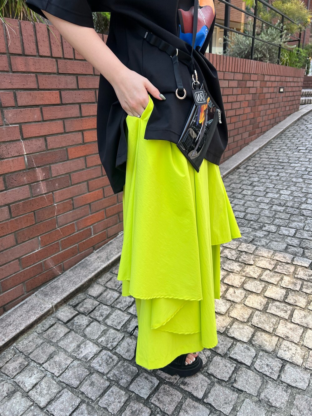 ブラック系のTシャツ/カットソー、イエロー系のその他パンツ、ブラック系のサンダルを着用したレディースの春コーディネートの7枚目の写真