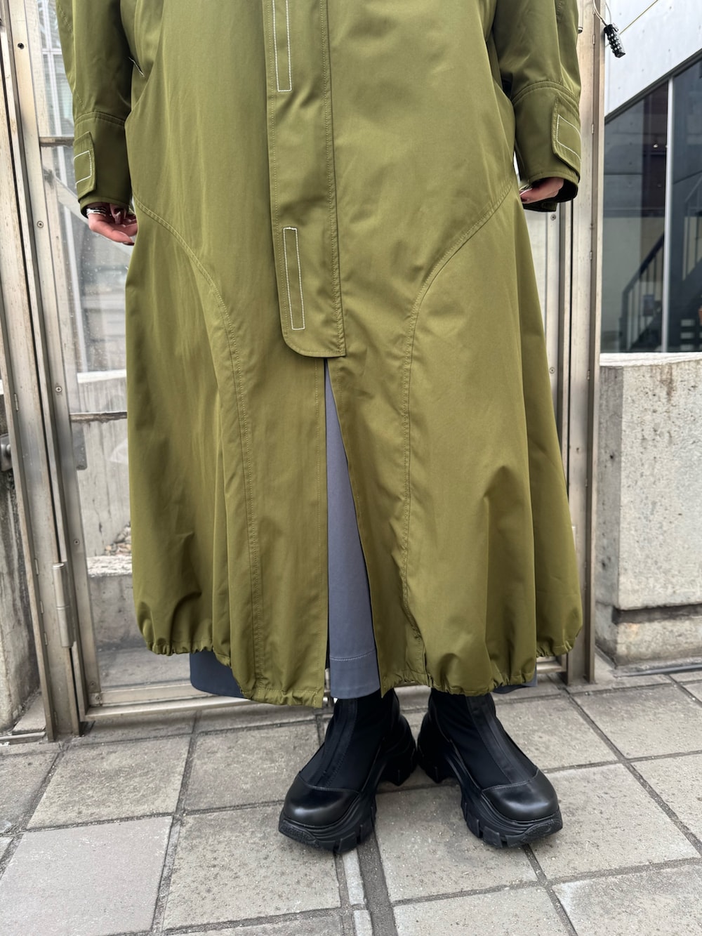 グリーン系のその他アウター、ブラック系のブーツを着用したレディースの冬コーディネートの4枚目の写真