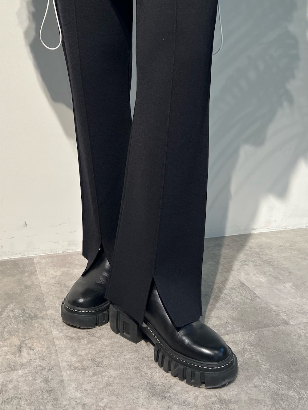 パープル系のニット/セーター、ブラック系のその他パンツ、ブラック系のブーツを着用したレディースの秋コーディネートの5枚目の写真