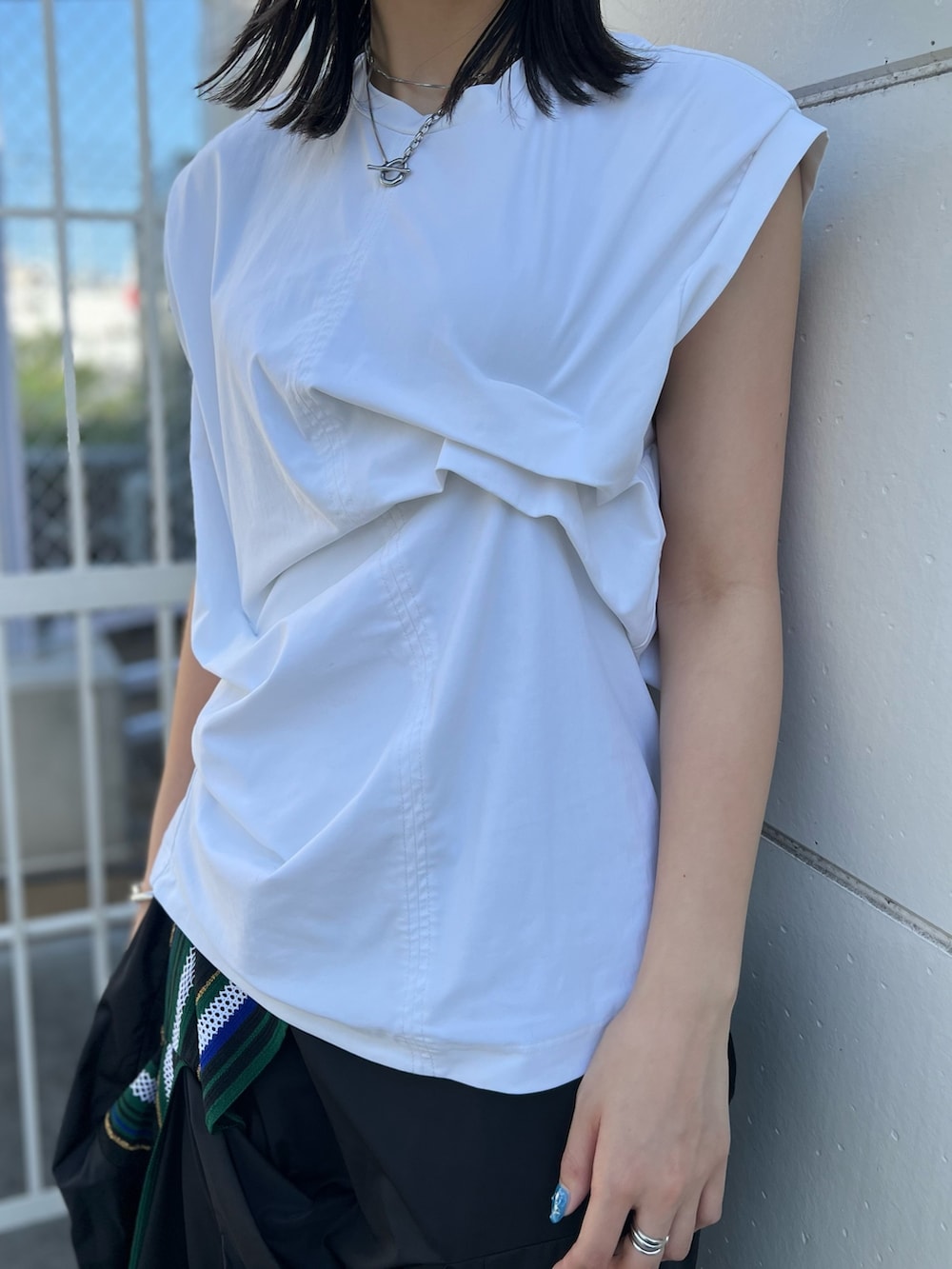 ホワイト系のTシャツ/カットソー、グリーン系のスカート、シルバー系のパンプスを着用したレディースの夏コーディネートの4枚目の写真