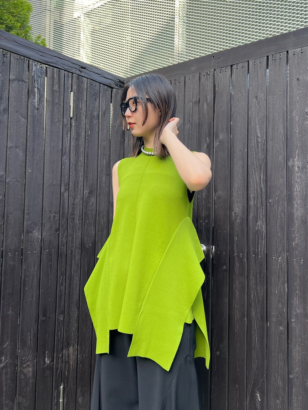 グリーン系のニット/セーター、ブラック系のその他パンツ、その他のサンダルを着用したレディースの春コーディネートの3枚目の写真