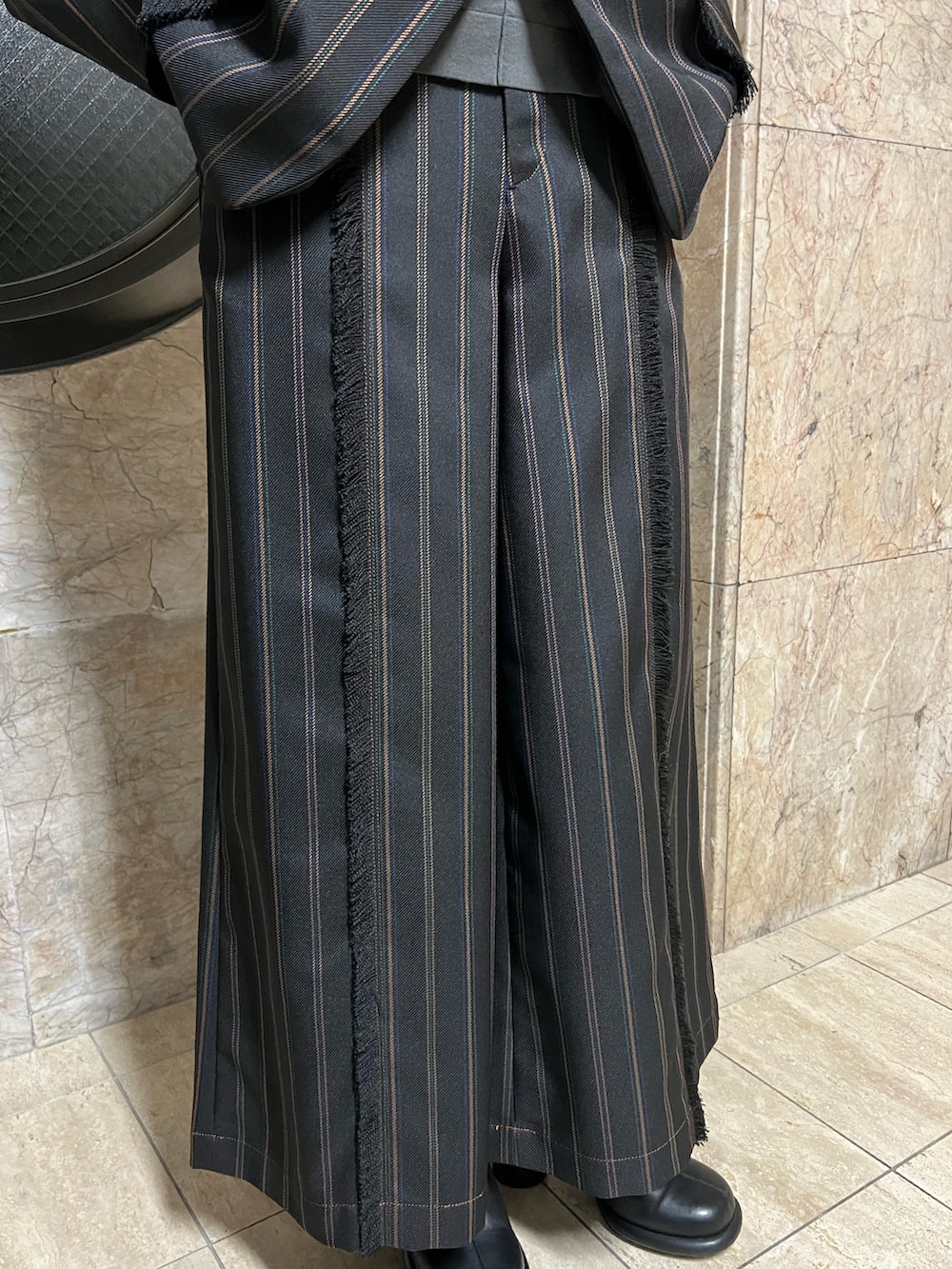 ブラック系のテーラードジャケット、ブラック系のブーツ、ブラック系のスラックスを着用したレディースの冬コーディネートの7枚目の写真