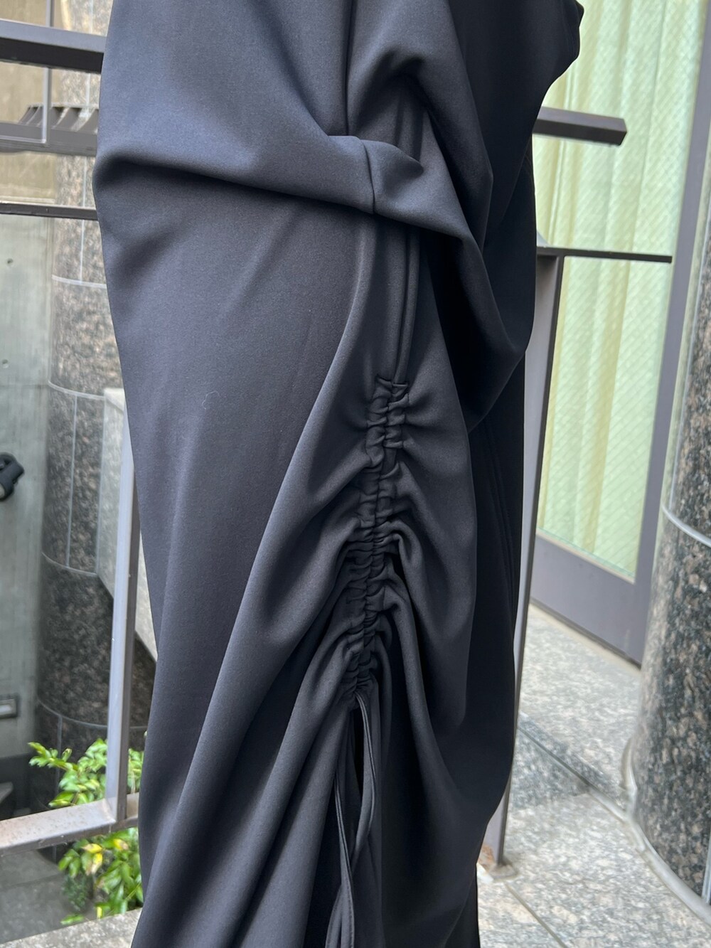 ブラック系のワンピース、ゴールド系のパンプス、ゴールド系のイヤリングを着用したレディースの冬コーディネートの5枚目の写真