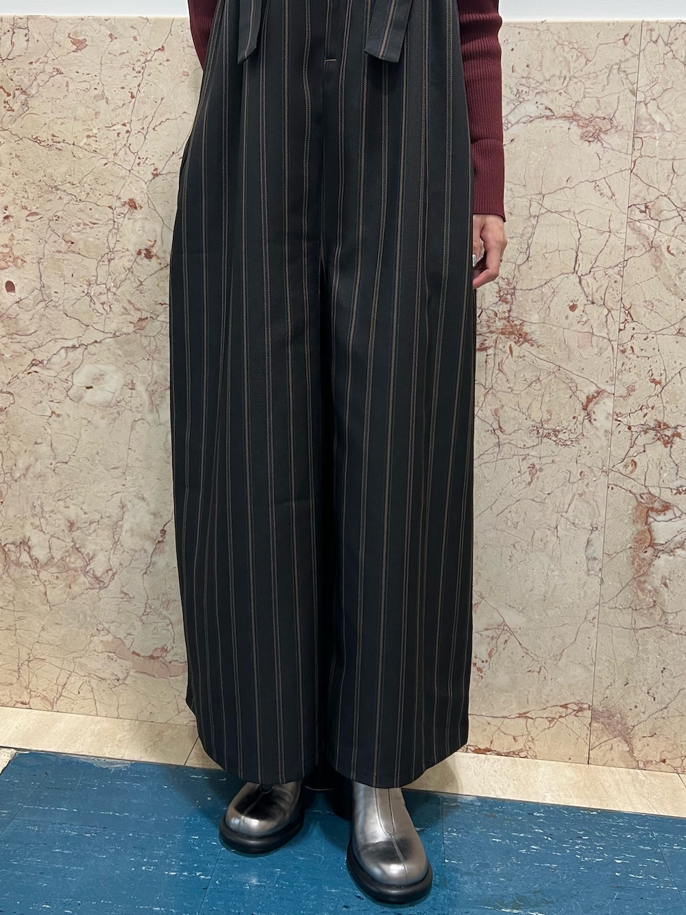 ブラック系のつなぎ/オールインワン、ブラウン系のニット/セーター、シルバー系のブーツを着用したレディースの夏コーディネートの6枚目の写真