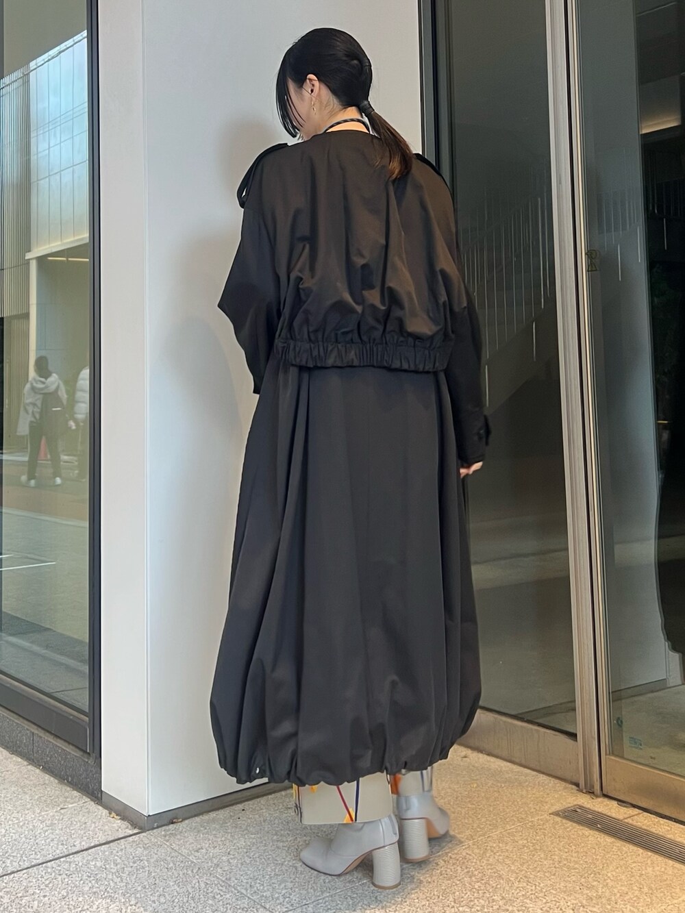 ブラック系のトレンチコート、ベージュ系のその他パンツ、ベージュ系のブーツを着用したレディースの冬コーディネートの2枚目の写真