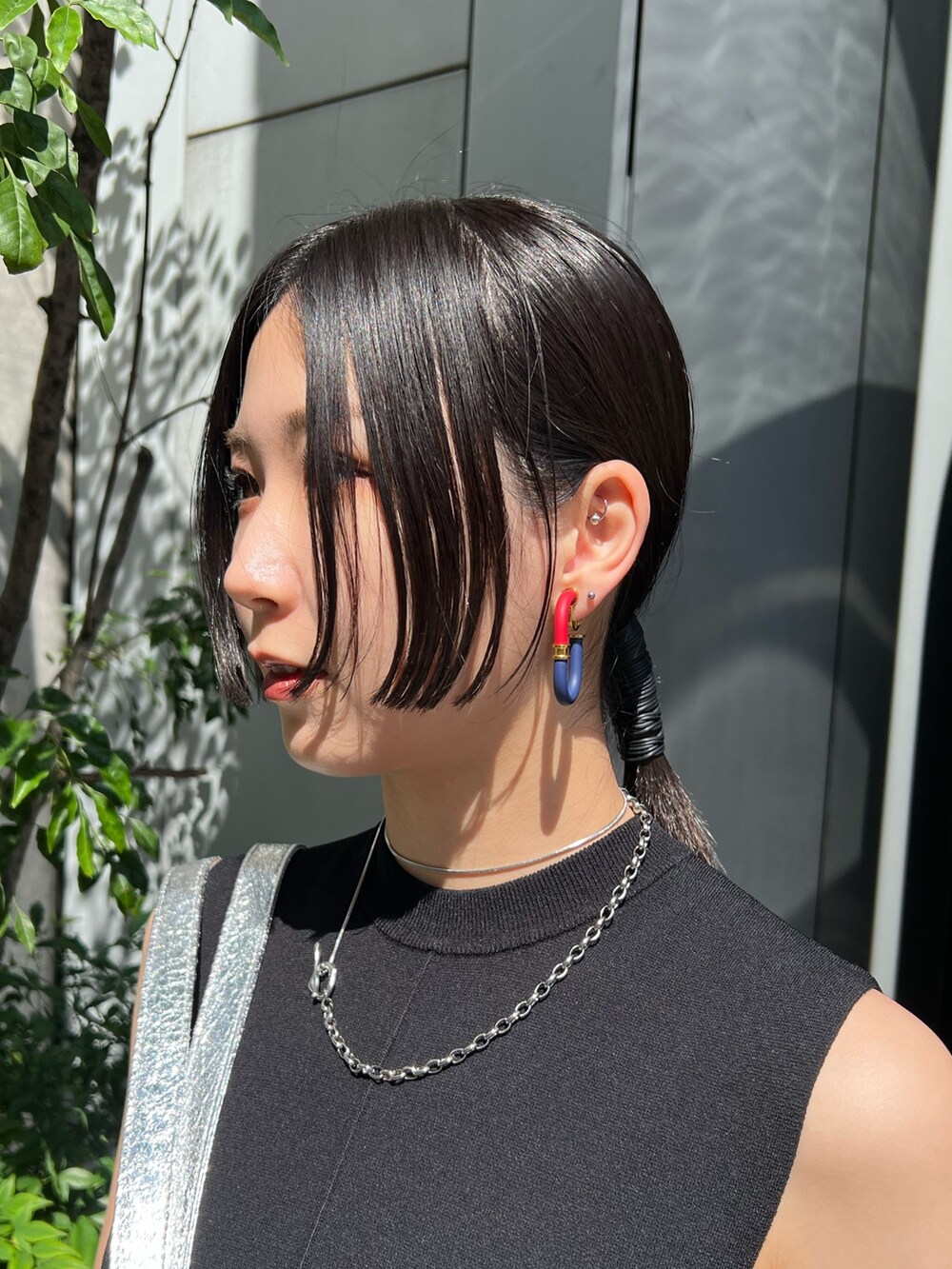 ブラック系のニット/セーター、ブラック系のスカート、シルバー系のトートバッグを着用したレディースの夏コーディネートの4枚目の写真