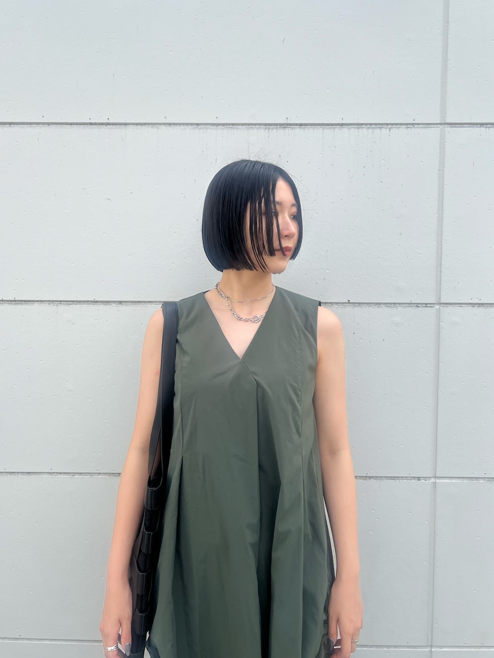 グリーン系のワンピース、ブラック系のトートバッグ、ブラック系のサンダルを着用したレディースの夏コーディネートの4枚目の写真