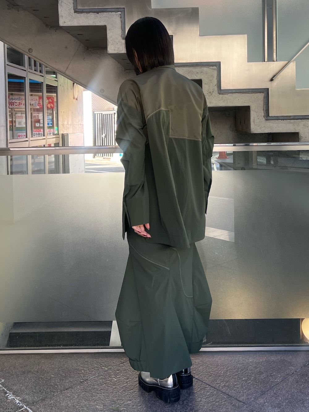 グリーン系のシャツ/ブラウス、グリーン系のスカート、シルバー系のブーツを着用したレディースの冬コーディネートの2枚目の写真