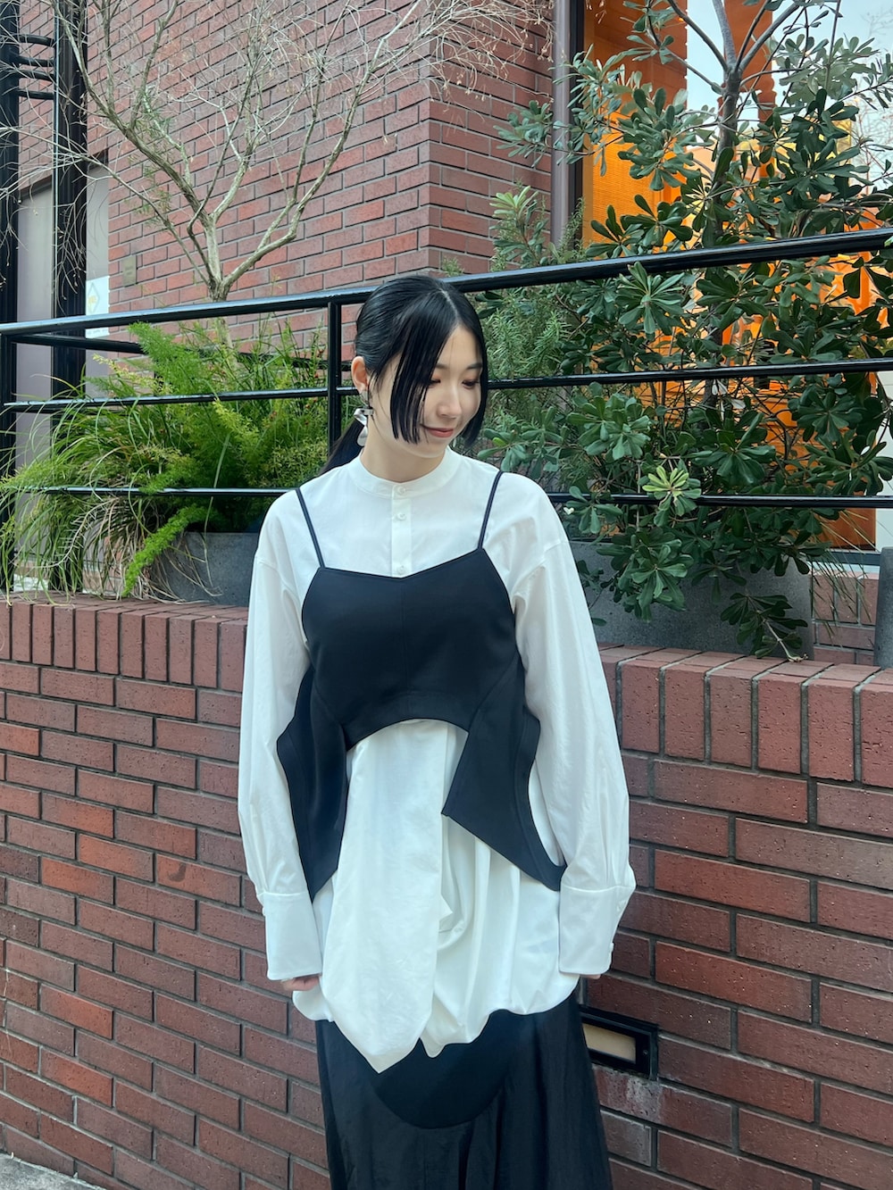 ブラック系のキャミソール、ホワイト系のシャツ/ブラウス、ブラック系のスカートを着用したレディースの冬コーディネートの4枚目の写真