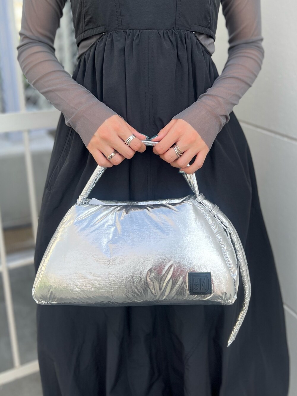 ブラック系のワンピース、グレー系のTシャツ/カットソー、シルバー系のハンドバッグを着用したレディースの夏コーディネートの5枚目の写真