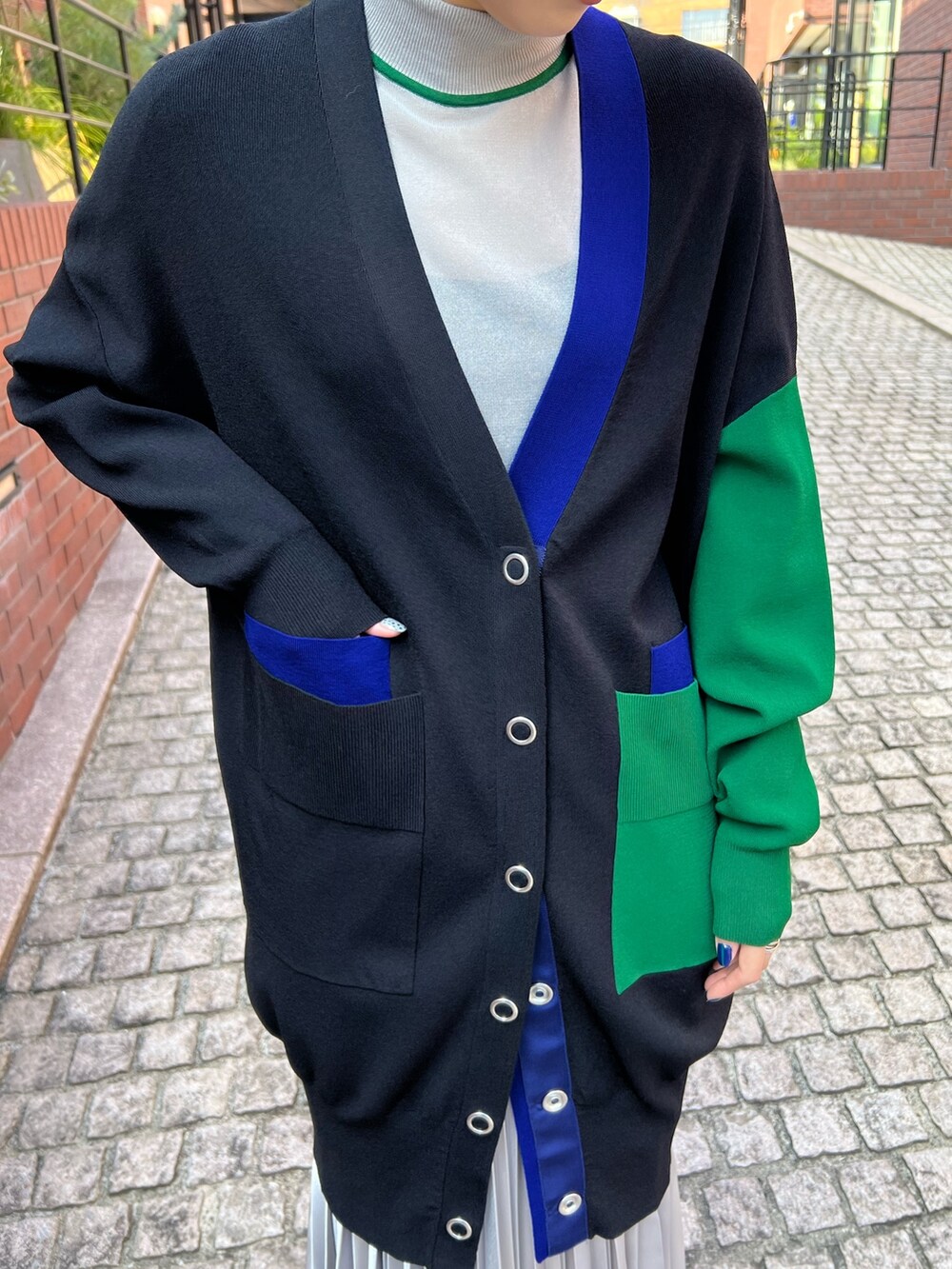 ブラック系のカーディガン/ボレロ、グレー系のニット/セーター、シルバー系のスカートを着用したレディースの秋コーディネートの3枚目の写真