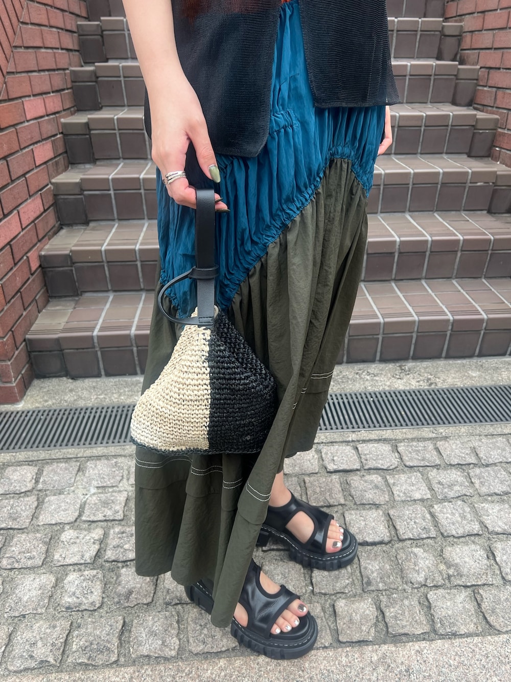 ブラック系のニット/セーター、その他のワンピース、ブラック系のハンドバッグを着用したレディースの春コーディネートの5枚目の写真