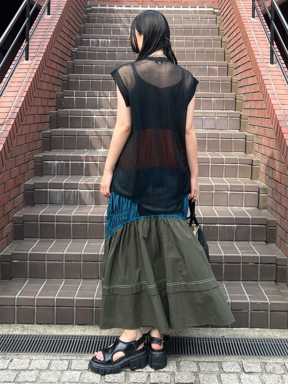 ブラック系のニット/セーター、その他のワンピース、ブラック系のハンドバッグを着用したレディースの春コーディネートの2枚目の写真