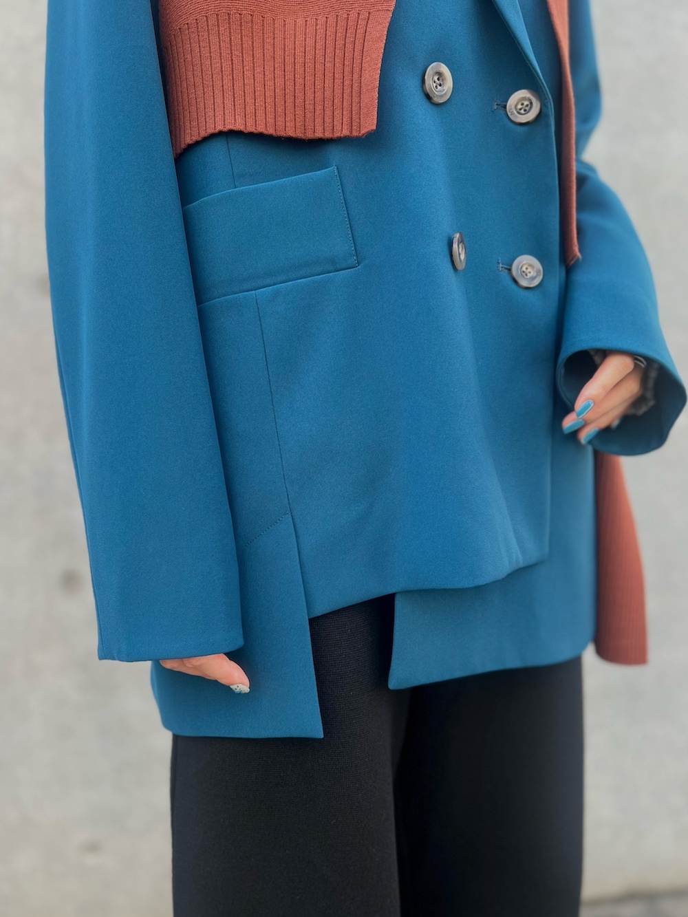 ブルー系のテーラードジャケット、ブラック系のその他パンツ、ブラック系のブーツを着用したレディースの秋コーディネートの6枚目の写真