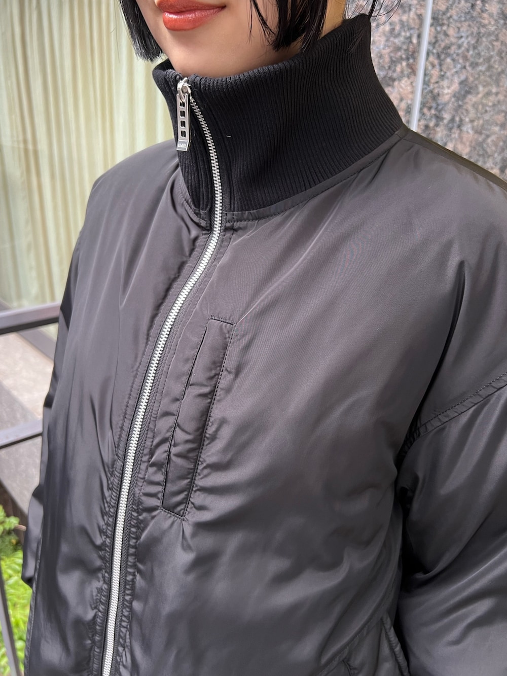 ブラック系のダウンジャケット/コート、グレー系のワンピース、ブラック系のブーツを着用したレディースの夏コーディネートの5枚目の写真