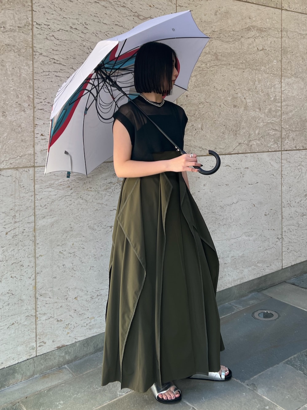 ベージュ系のワンピース、シルバー系のサンダル、ブラック系のニット/セーターを着用したレディースの春コーディネートの2枚目の写真