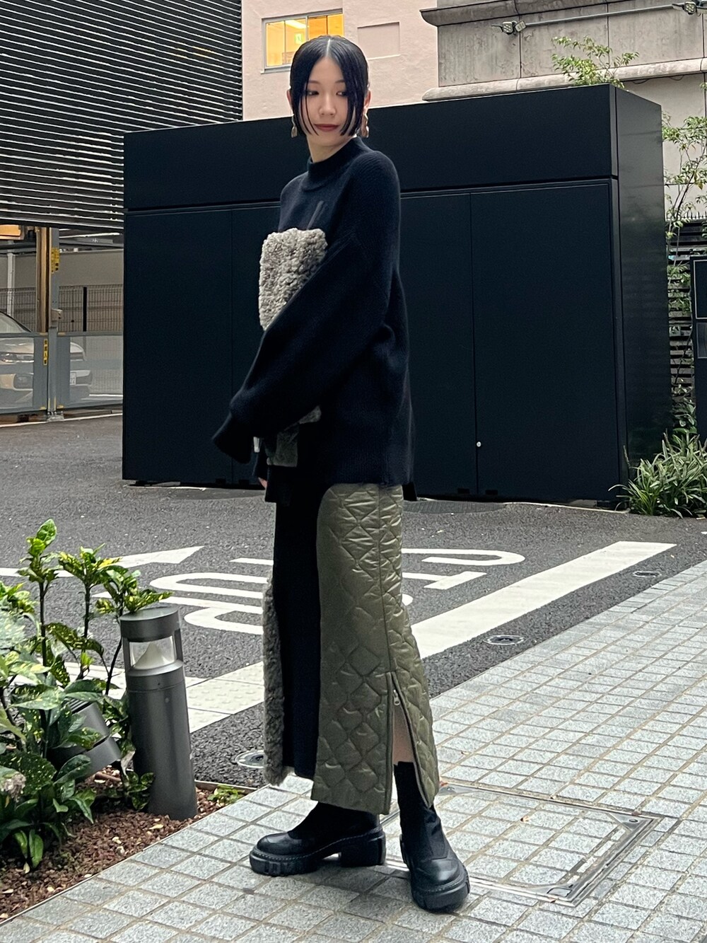 ブラック系のニット/セーター、ブラック系のスカート、ブラック系のブーツを着用したレディースの秋コーディネートの2枚目の写真