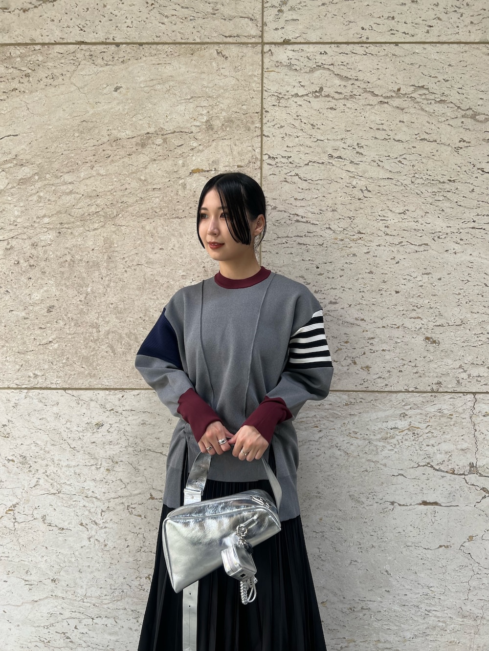シルバー系のブーツ、ブラック系のスカート、グレー系のニット/セーターを着用したレディースの秋コーディネートの3枚目の写真