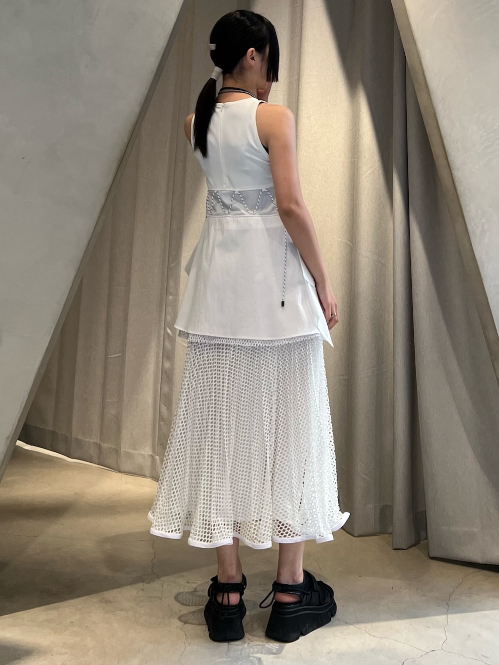 ホワイト系のタンクトップ、ホワイト系のスカート、ブラック系のサンダルを着用したレディースの冬コーディネートの2枚目の写真