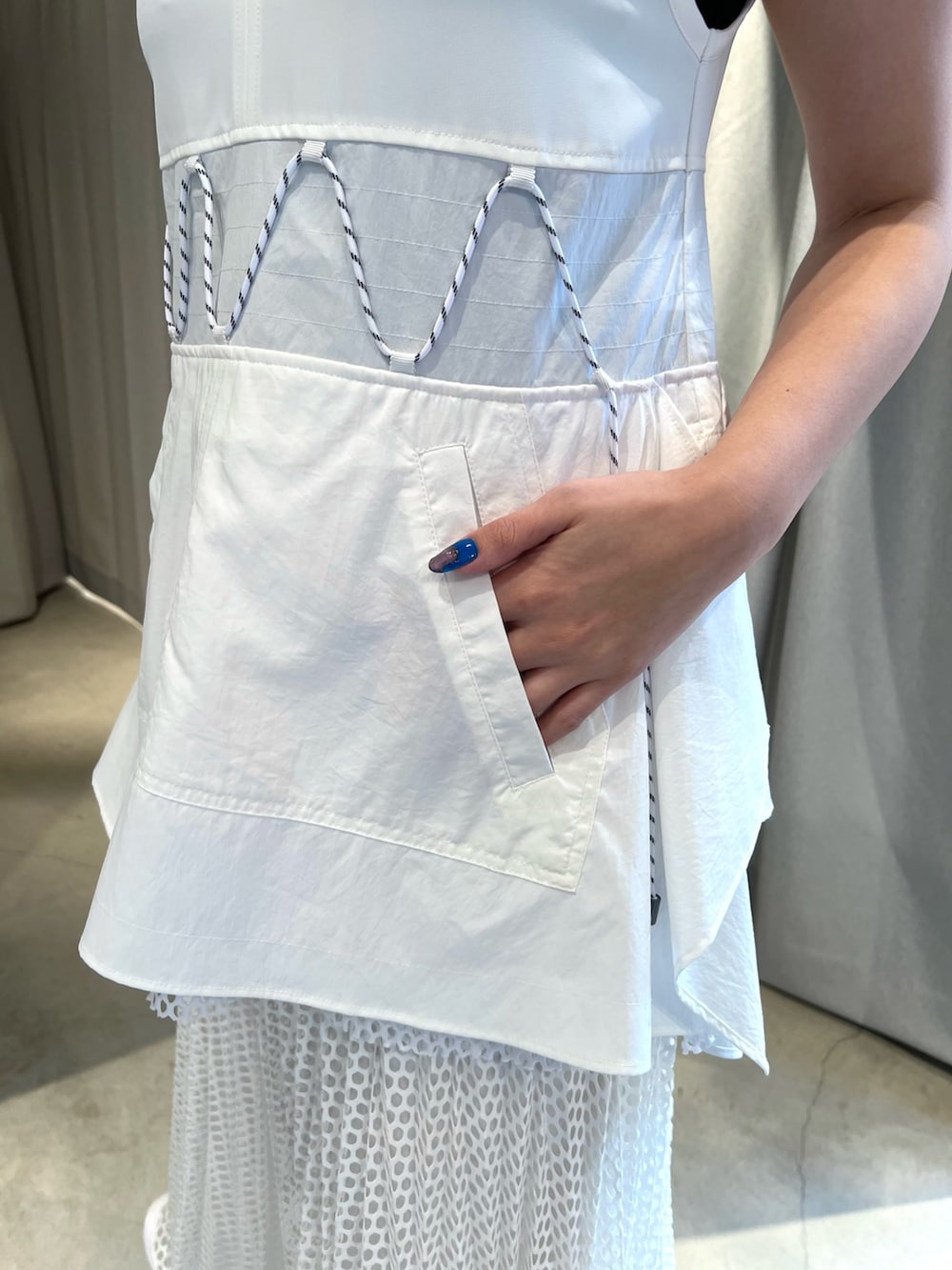 ホワイト系のタンクトップ、ホワイト系のスカート、ブラック系のサンダルを着用したレディースの冬コーディネートの5枚目の写真